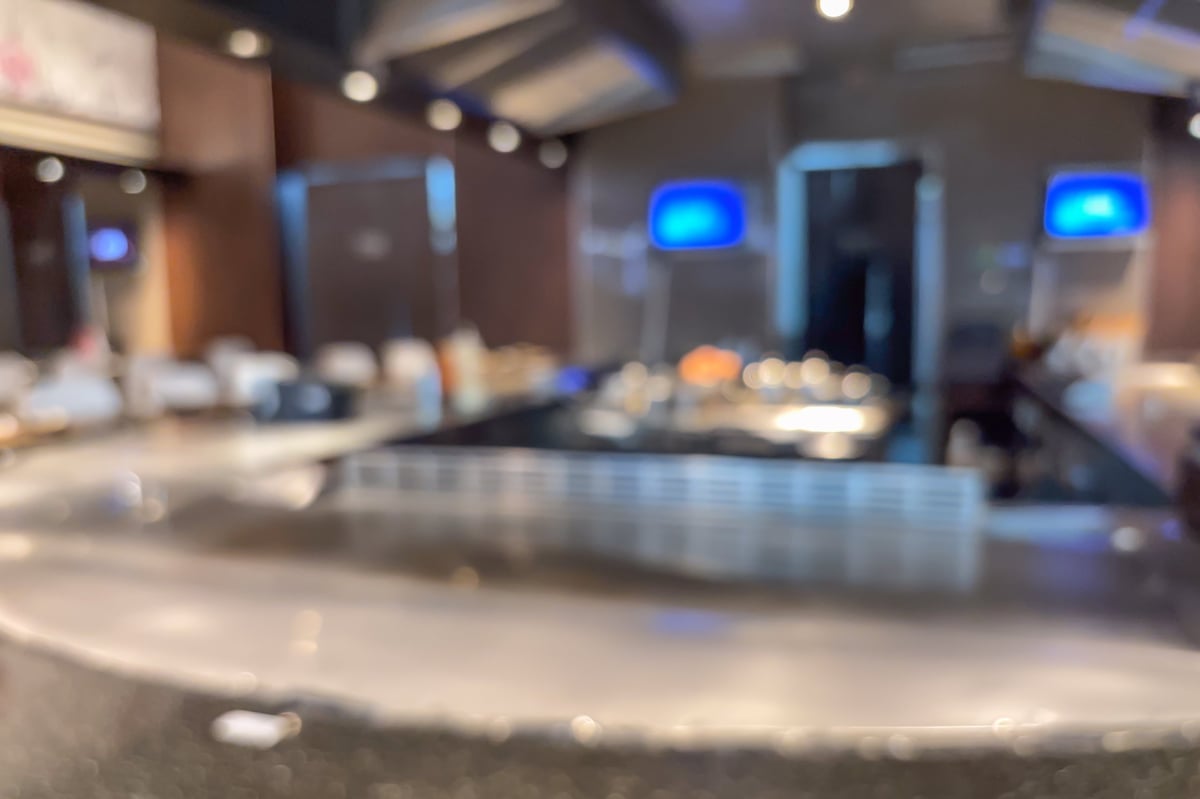 Warm tavern interior with amber pendant lighting over dining tables