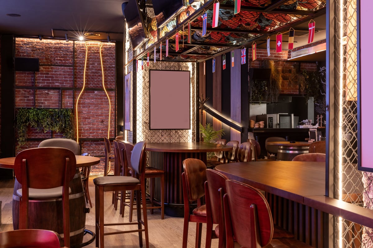 Sports bar interior with brick walls and wooden seating filled with guests